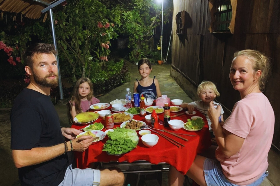 Family enjoying traditional dinner at a Vietnam homestay during cultural travel